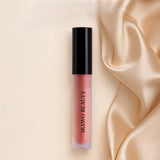 Lip gloss with black cap on a beige satin background