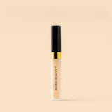 Concealer bottle with black and gold lid on a beige background