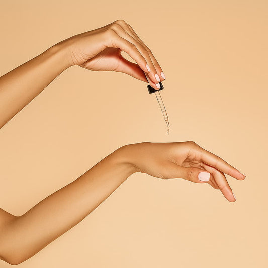 Hand holding a dropper with a beige background