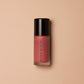 Blush bottle with black cap on a beige background